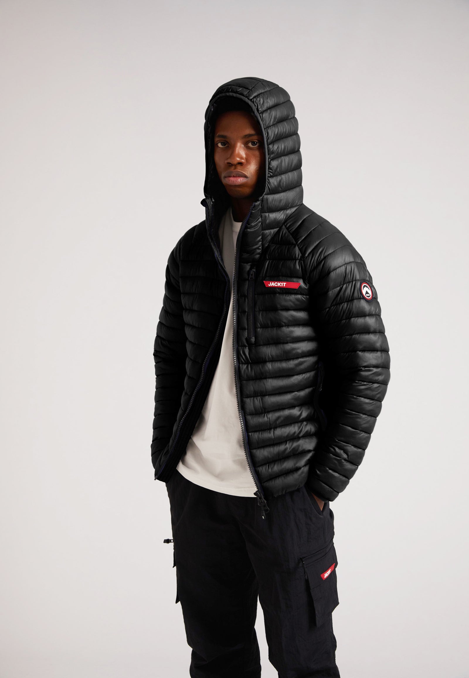 Model wearing SATEL1TE Hooded Jacket 2.0 Black with a hood, showcasing its stylish and versatile design.