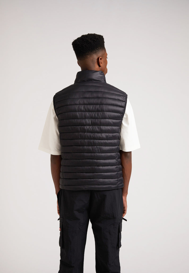 Back view of a model wearing the SATEL1TE Lightweight Puffer Gilet 2.0 Black, showcasing its sleek design.