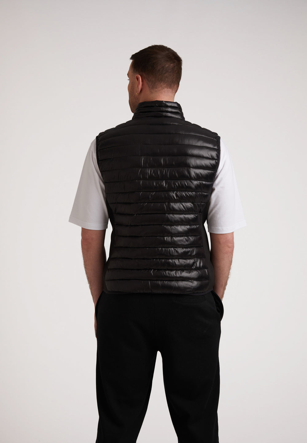 Back view of a man wearing a SPORTL1TE lightweight gilet for outdoor activities, featuring a sleek design.