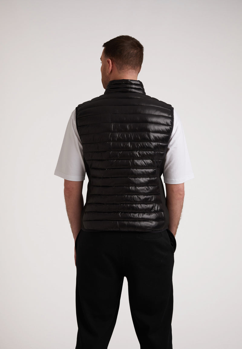 Back view of a man wearing a SPORTL1TE lightweight gilet for outdoor activities, featuring a sleek design.