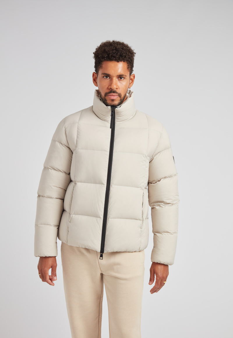 Model wearing Cloud Lightweight Puffer Racer Jacket Stone, showcasing its stylish and functional winter design.