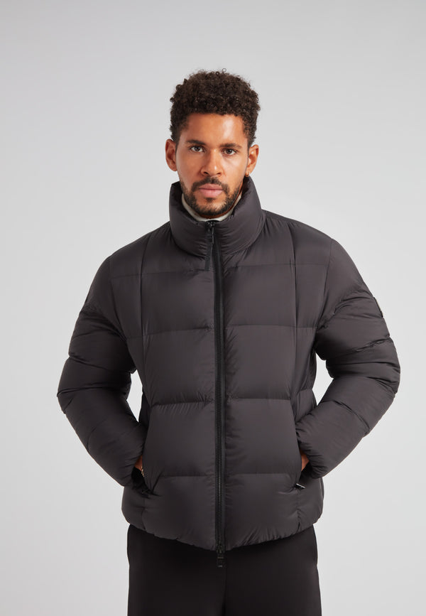 Man wearing Cloud Lightweight Puffer Racer Jacket Black, a sleek and insulated winter jacket.