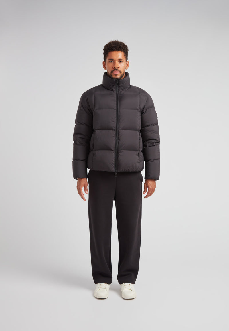 Cloud Lightweight Puffer Racer Jacket Black worn by a man, showcasing its modern style and warmth.