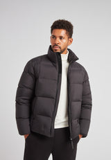 Model wearing Cloud Lightweight Puffer Racer Jacket Black, showcasing warmth and style for active winter wear.