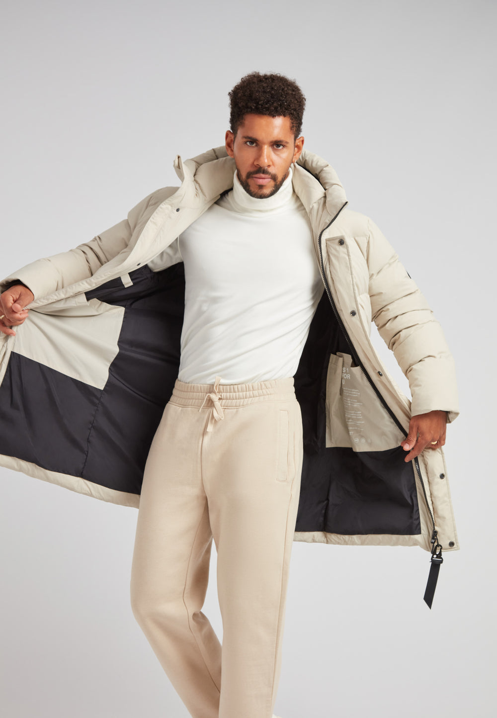Man wearing a Stone Nomad Down Parka Coat for Men, showcasing its interior and stylish design.