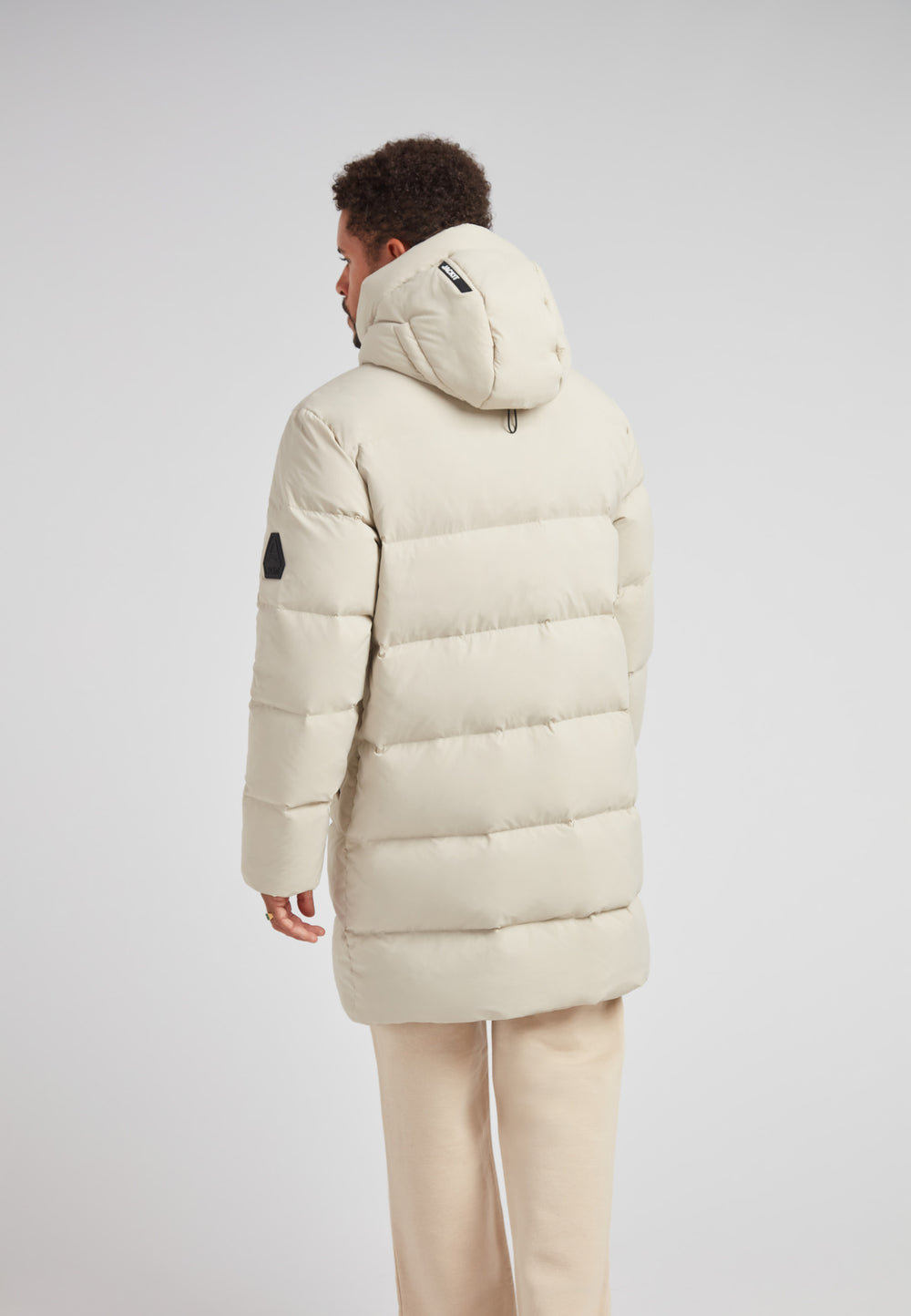 Stone Nomad Down Parka Coat for Men viewed from the back, showcasing hood and structured design.