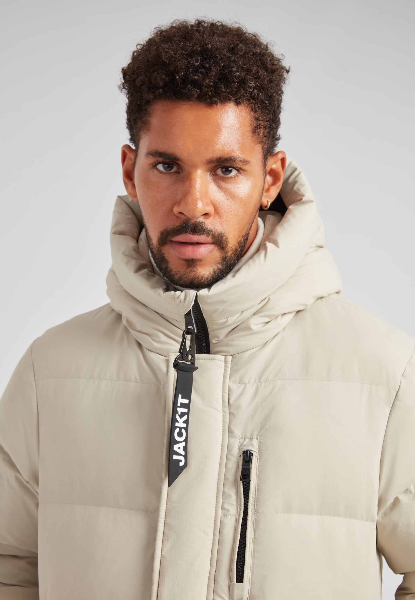 Stone Nomad Down Parka Coat for Men displayed on a model, featuring a high collar and sleek design.