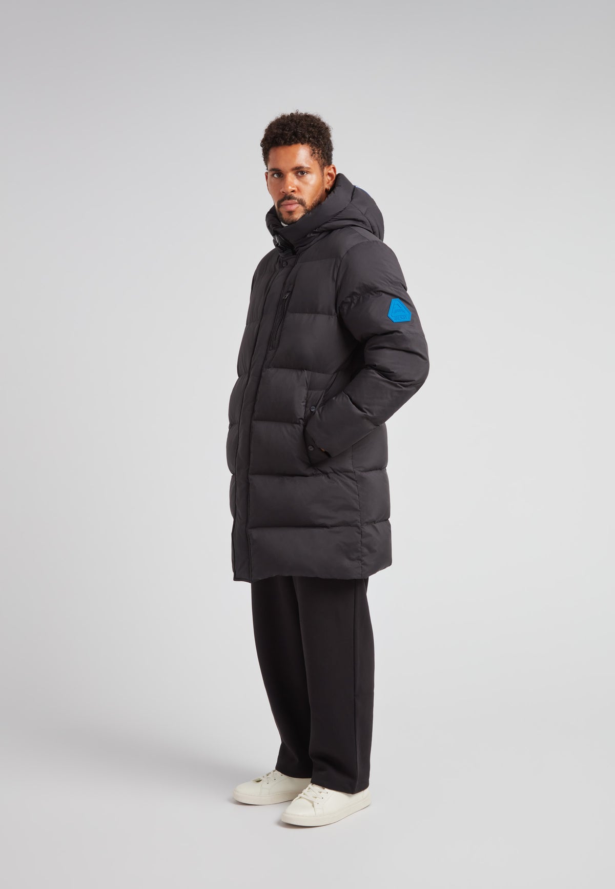 Man wearing the Nomad Parka Coat 2.0 Black, a Down Parka Coat for Men in Black, providing warmth and style.