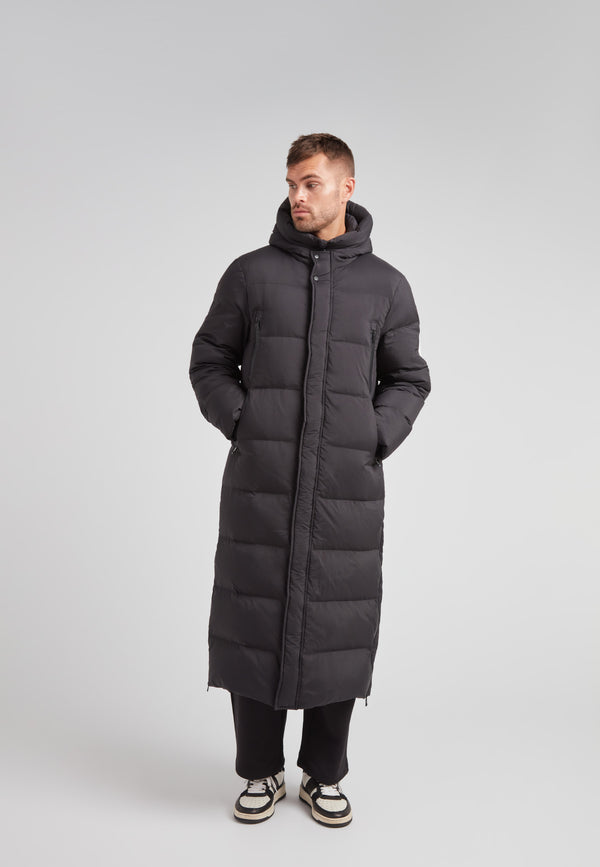 Mens Extra Long Puffer Coat in Black worn by a model, showcasing its stylish and warm design.