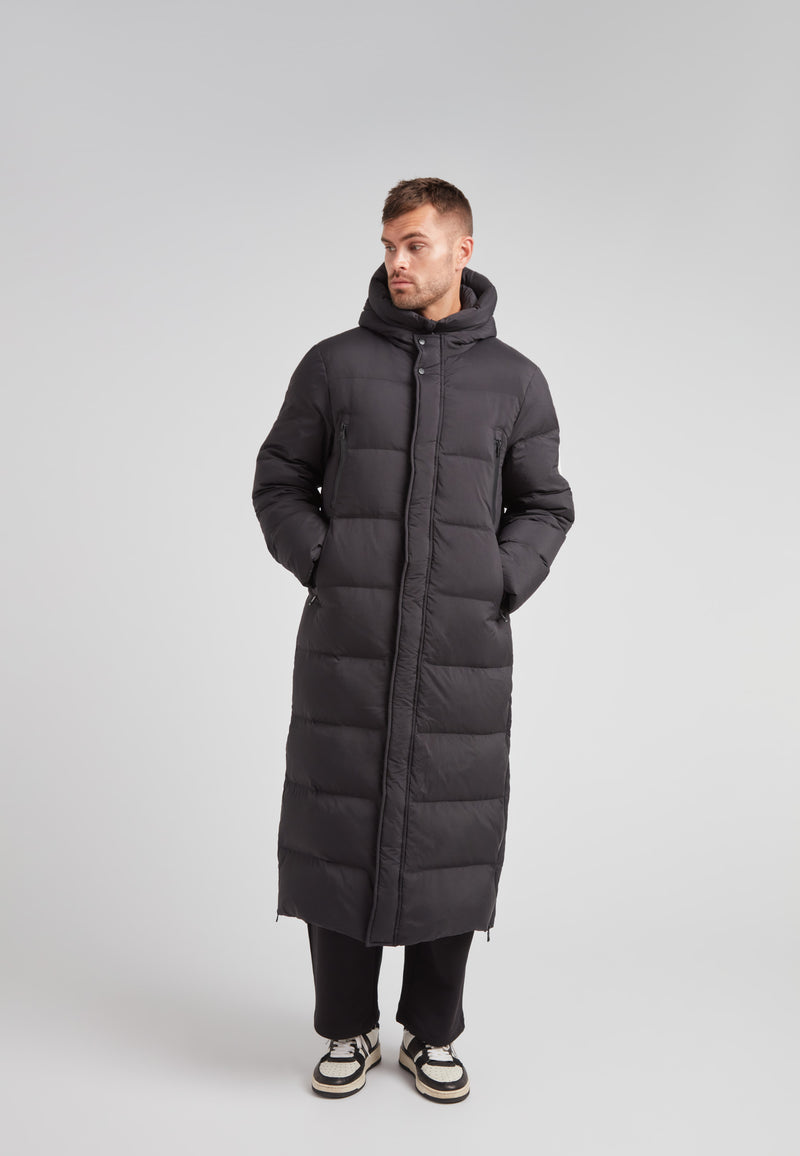 Mens Extra Long Puffer Coat in Black worn by a model, showcasing its stylish and warm design.