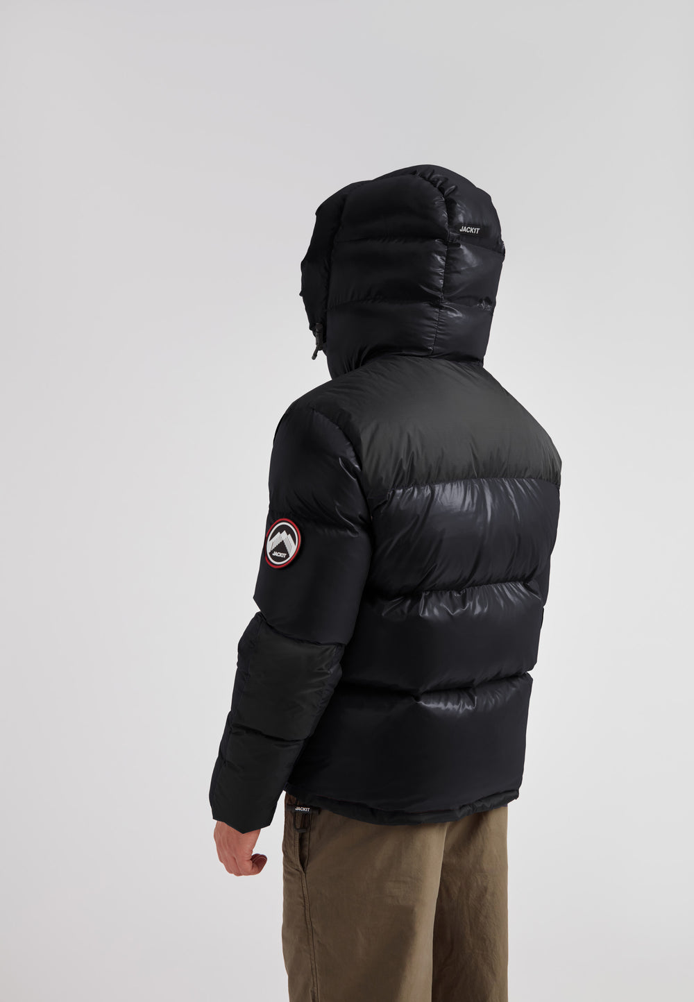 Back view of a man wearing the Expedition Parka Puffer Men Black jacket with oversized hood.
