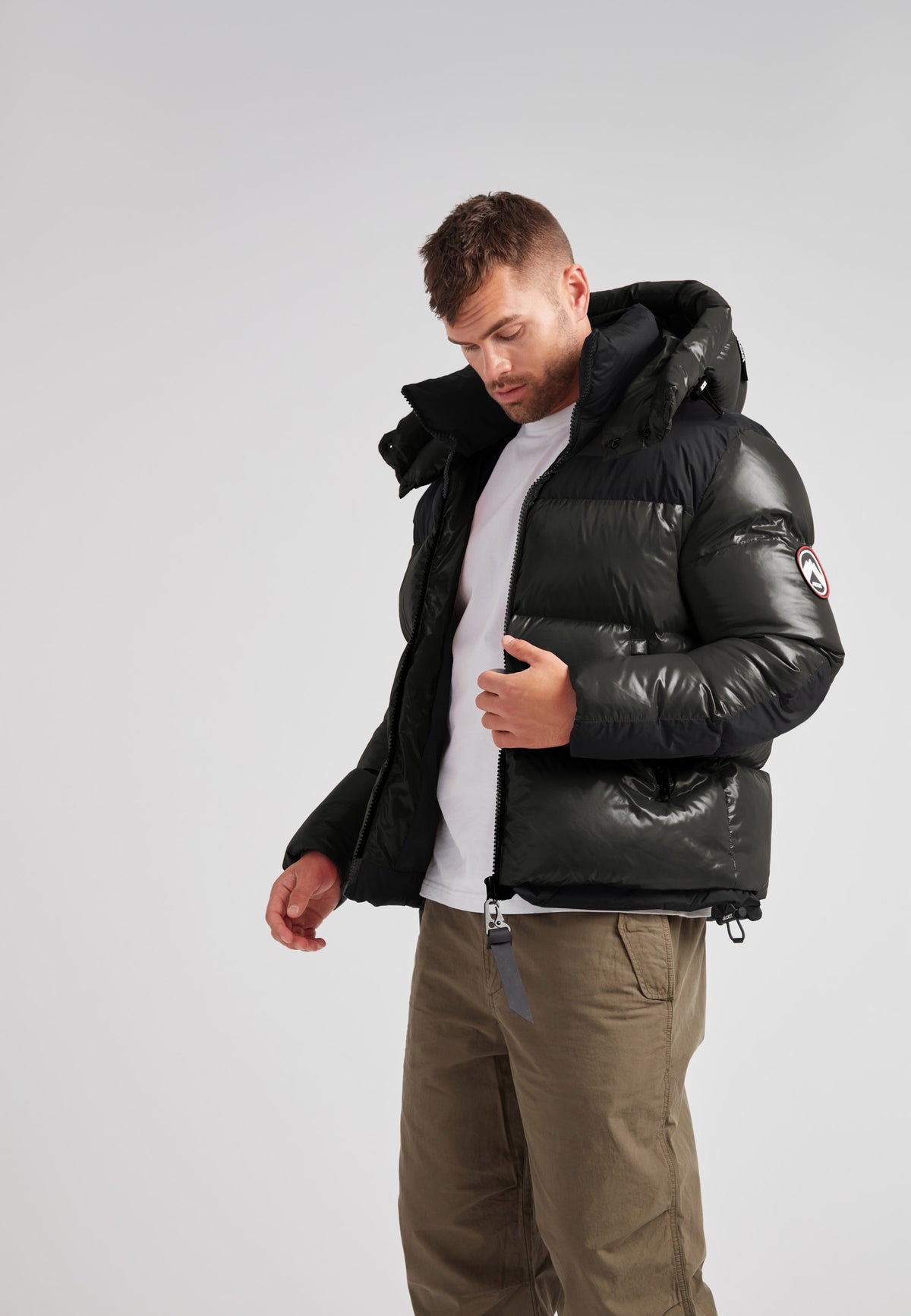 Expedition Parka Puffer Men Emerald in black worn by a man, featuring oversized hood and boxy silhouette.