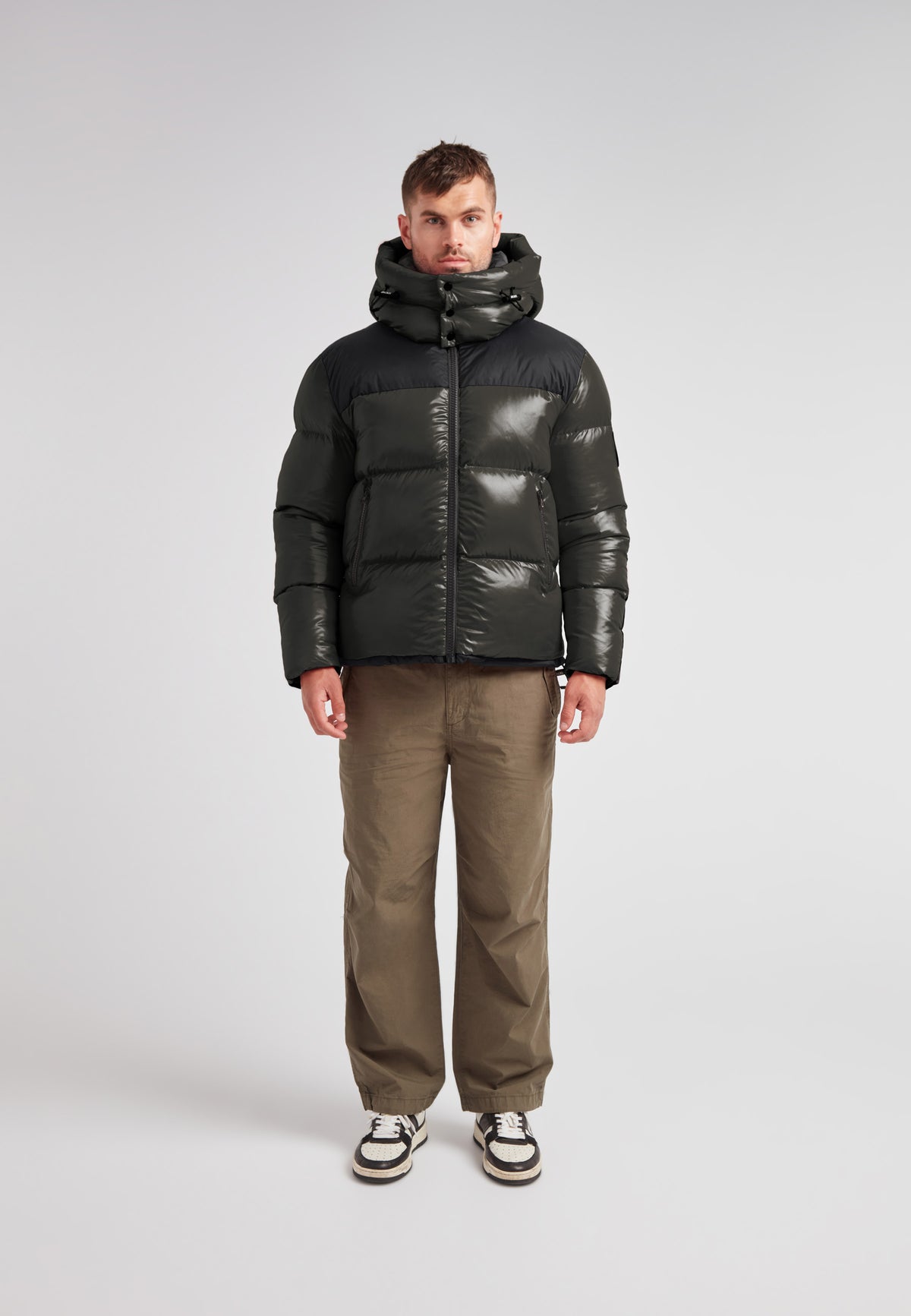 Expedition Parka Puffer Men Emerald worn by a model, featuring bold color blocking and an oversized hood.