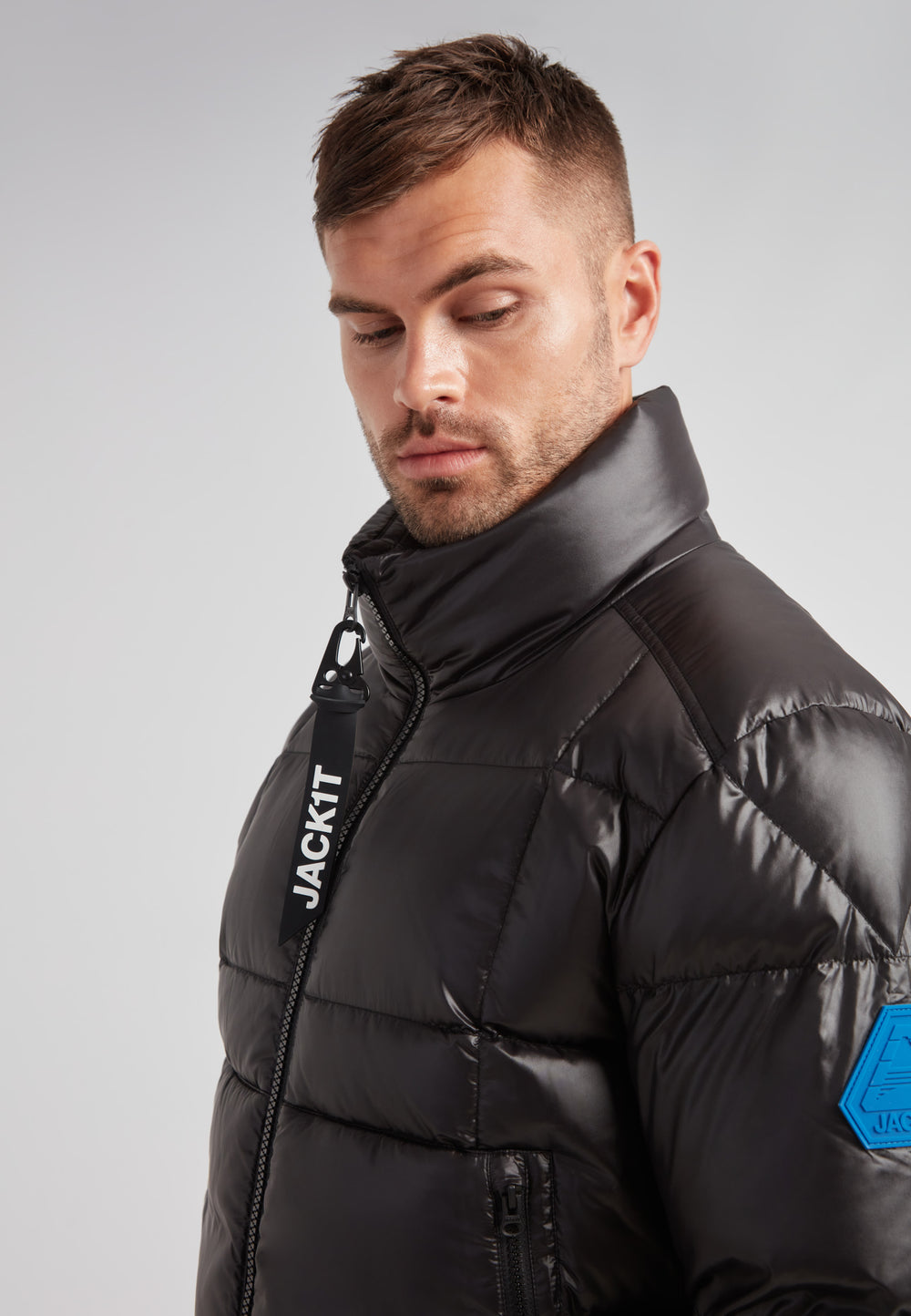 EZ Boxed Funnel Puffer Jacket Lux Black modeled by a man with a sleek design and a funnel neck for winter protection.