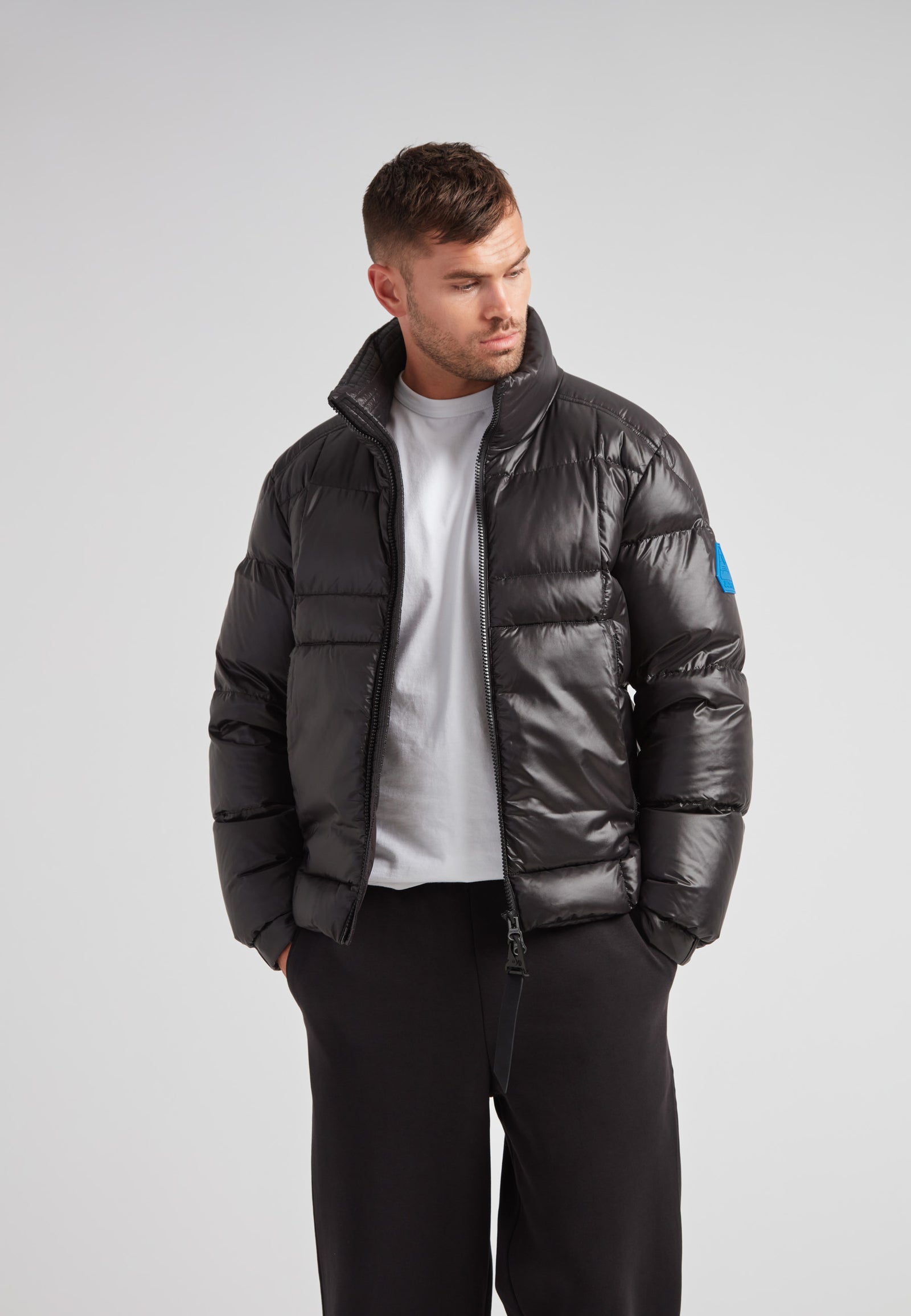 Man wearing the EZ Boxed Funnel Puffer Jacket Lux Black, showcasing its sleek design and winter-ready features.