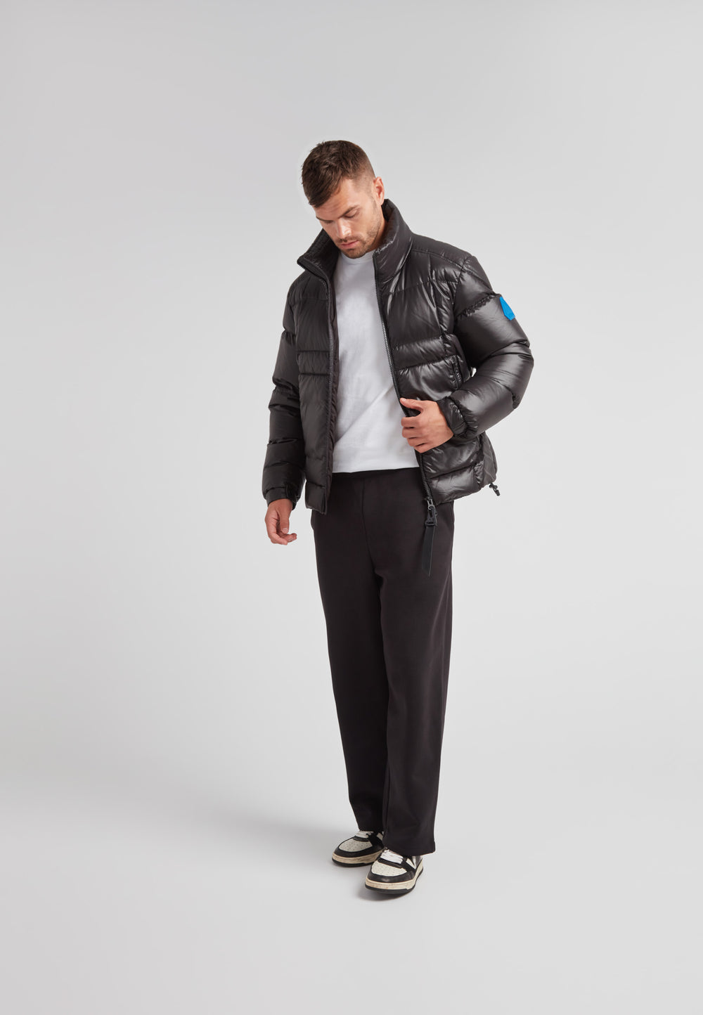 Man wearing EZ Boxed Funnel Puffer Jacket Lux Black with a casual outfit and stylish sneakers.