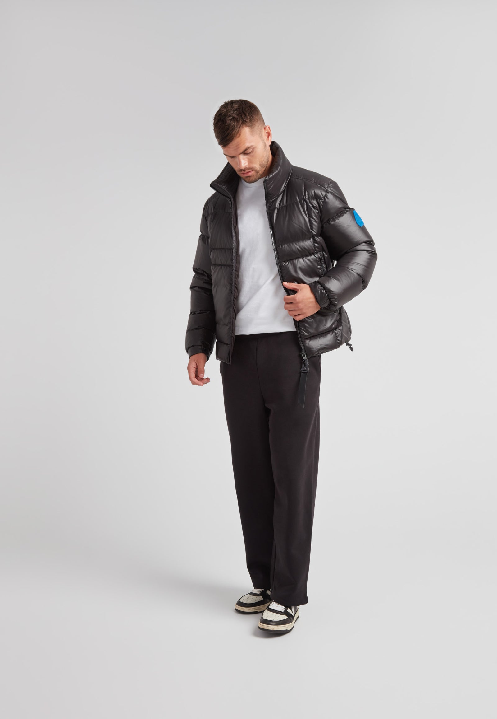 Man wearing EZ Boxed Funnel Puffer Jacket Lux Black with a casual outfit and stylish sneakers.