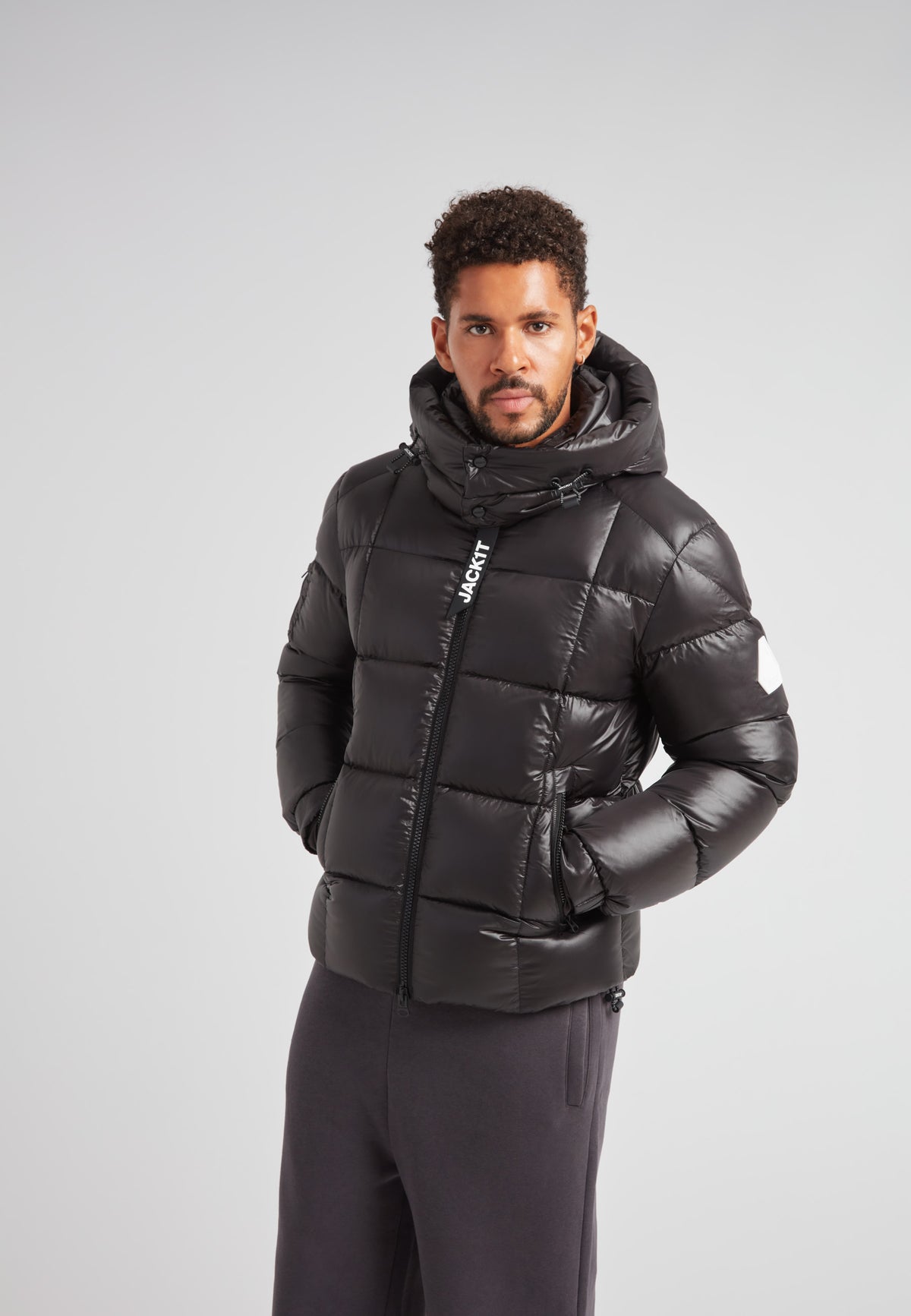 Man wearing EZ Boxed Puffer Racer Jacket Lux Black, a stylish black puffer jacket with a hood.