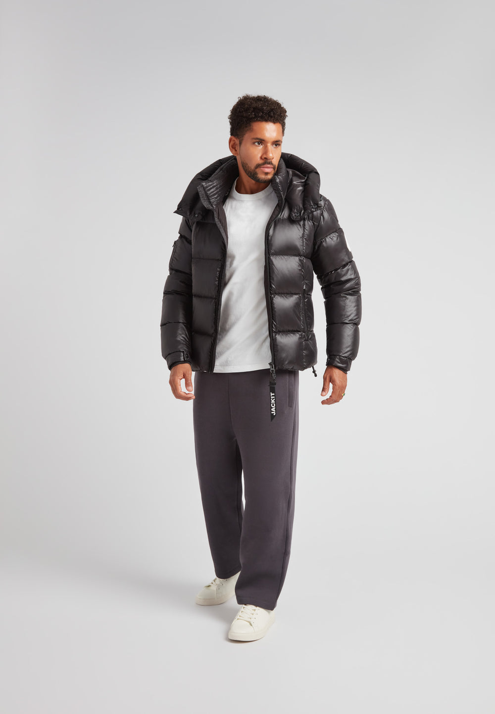 EZ Boxed Puffer Racer Jacket Lux Black worn by a man, showcasing its sleek urban design and warmth.