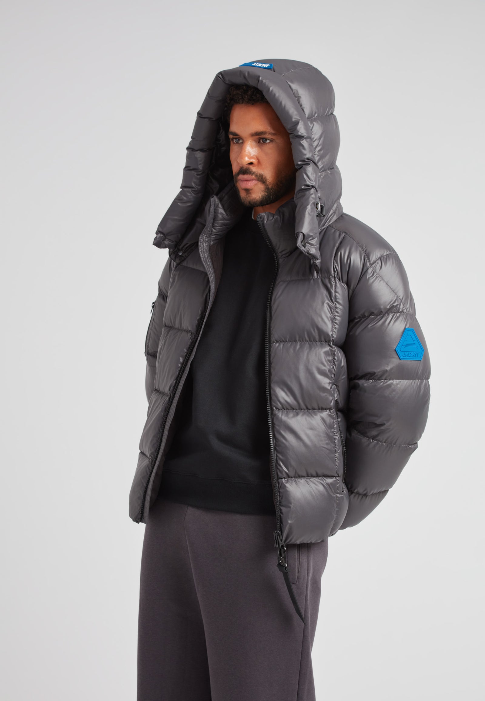 EZ Boxed Puffer Racer Jacket Lux Graphite worn by a man, featuring a hood and sleek design for winter protection.