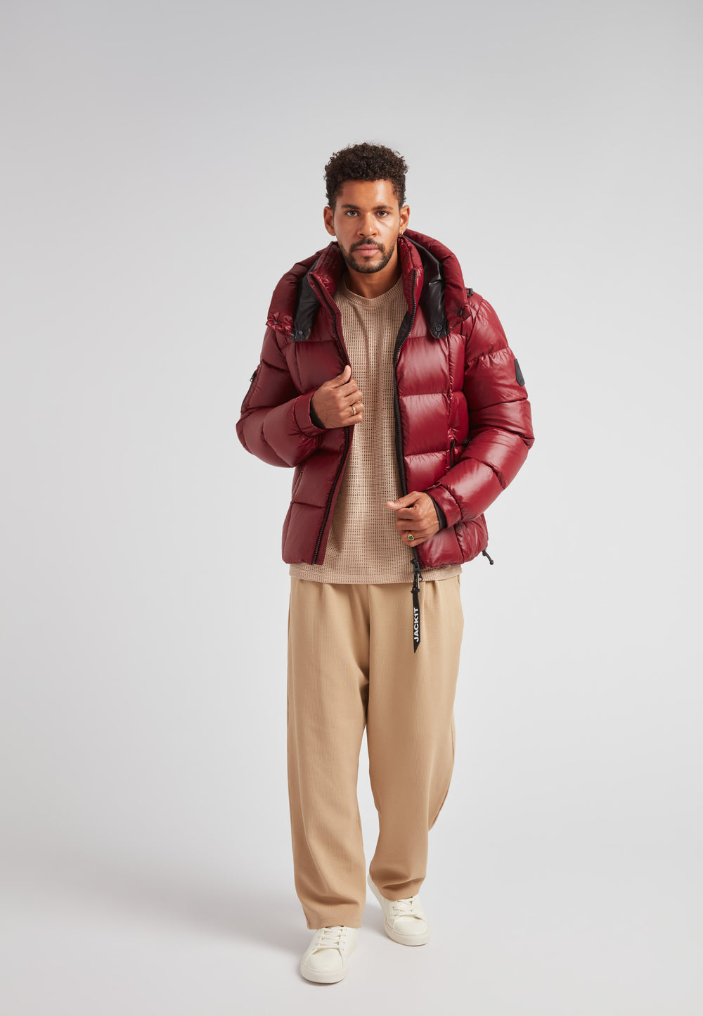 Man wearing EZ Boxed Puffer Racer Jacket Lux Red over a beige shirt and pants.