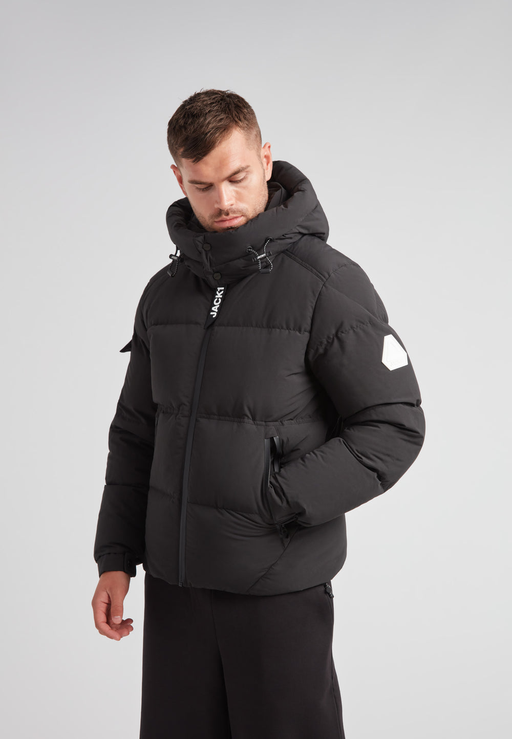 Man wearing the EZ Water Puffer Racer Jacket Matt Black, showcasing its winter style and features.