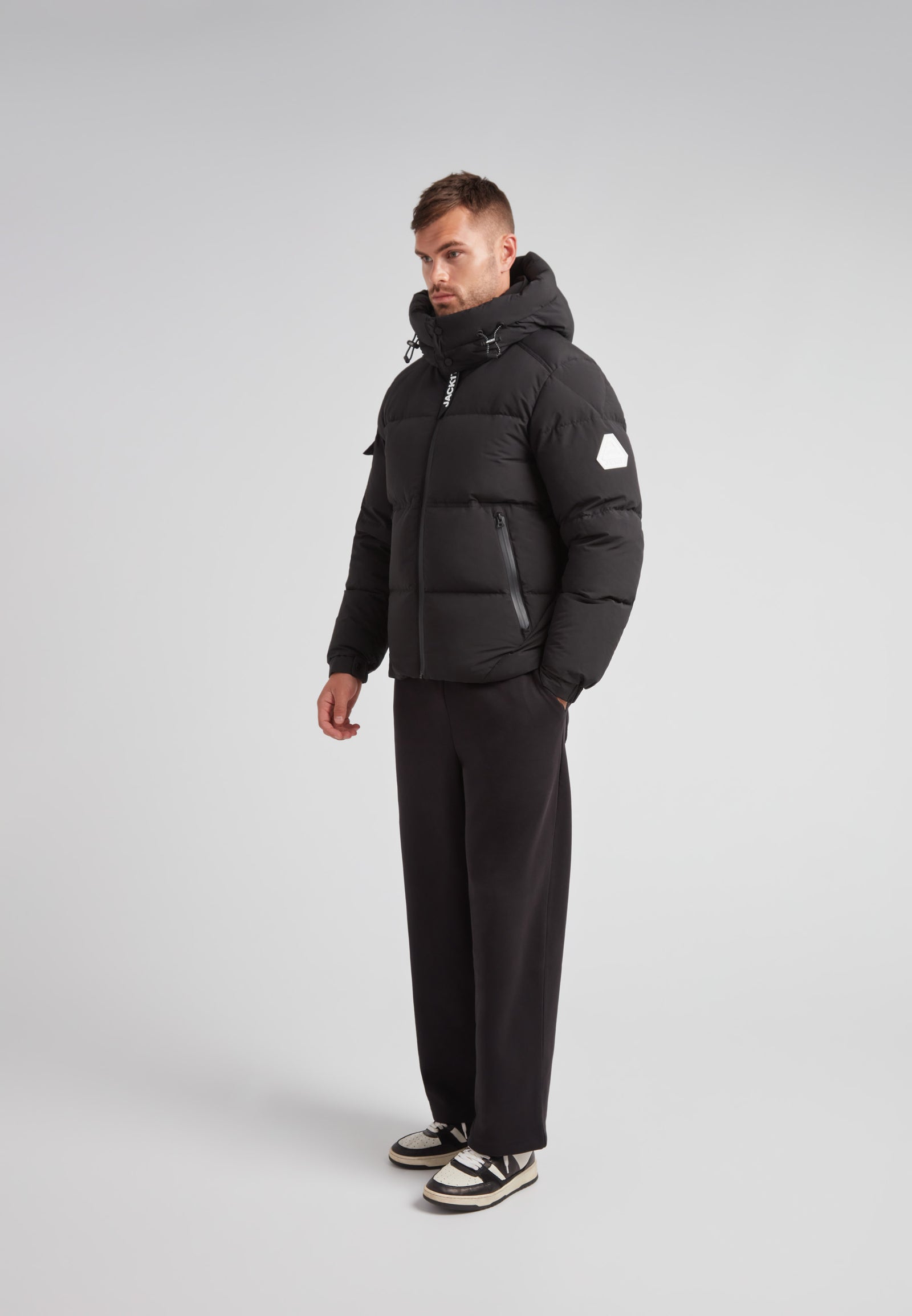 EZ Water Puffer Racer Jacket Matt Black worn by a man, showcasing its stylish and functional design.