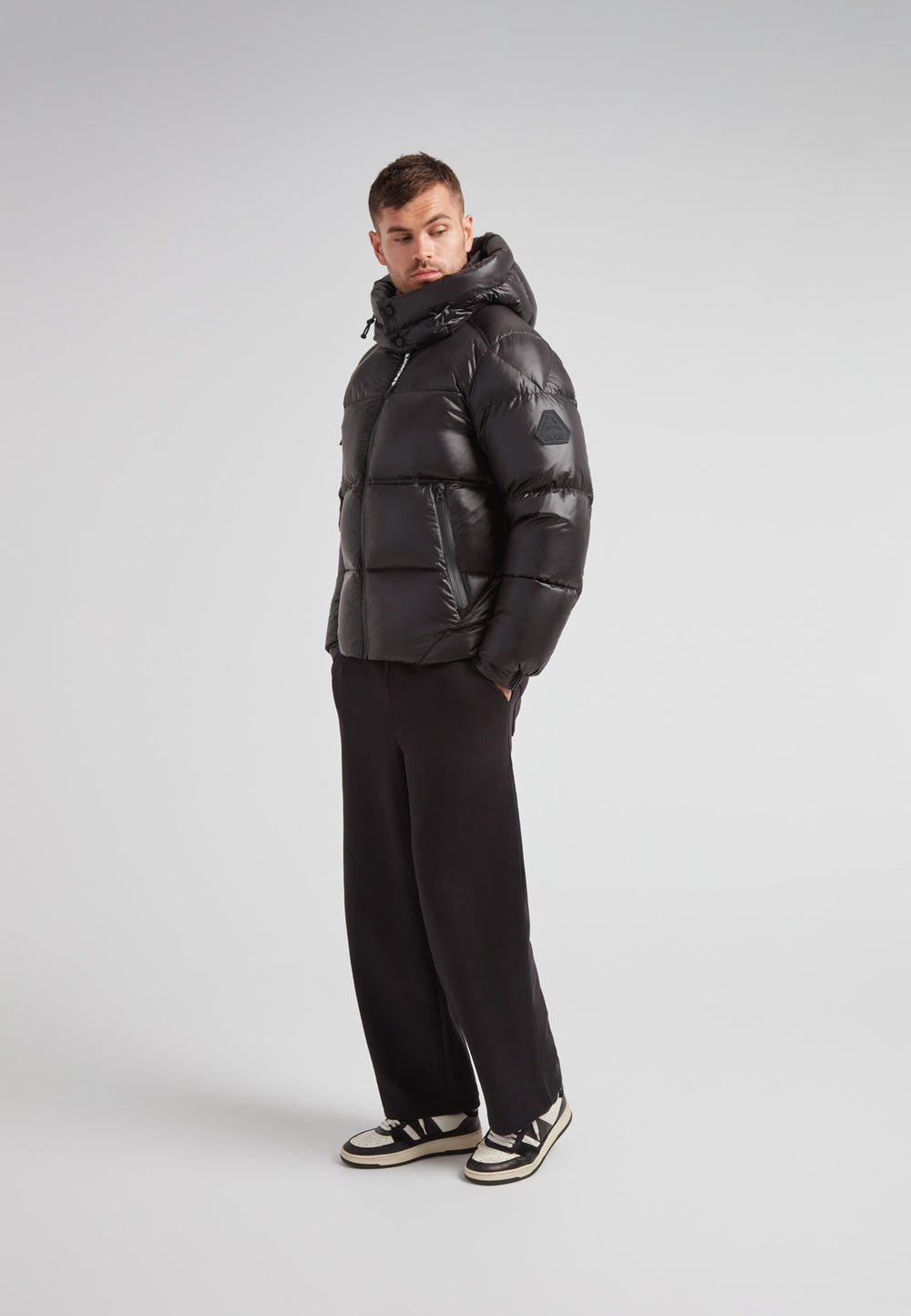 Model wearing the EZ Water Puffer Racer Jacket Lux Black, showcasing its sleek design and winter-ready features.