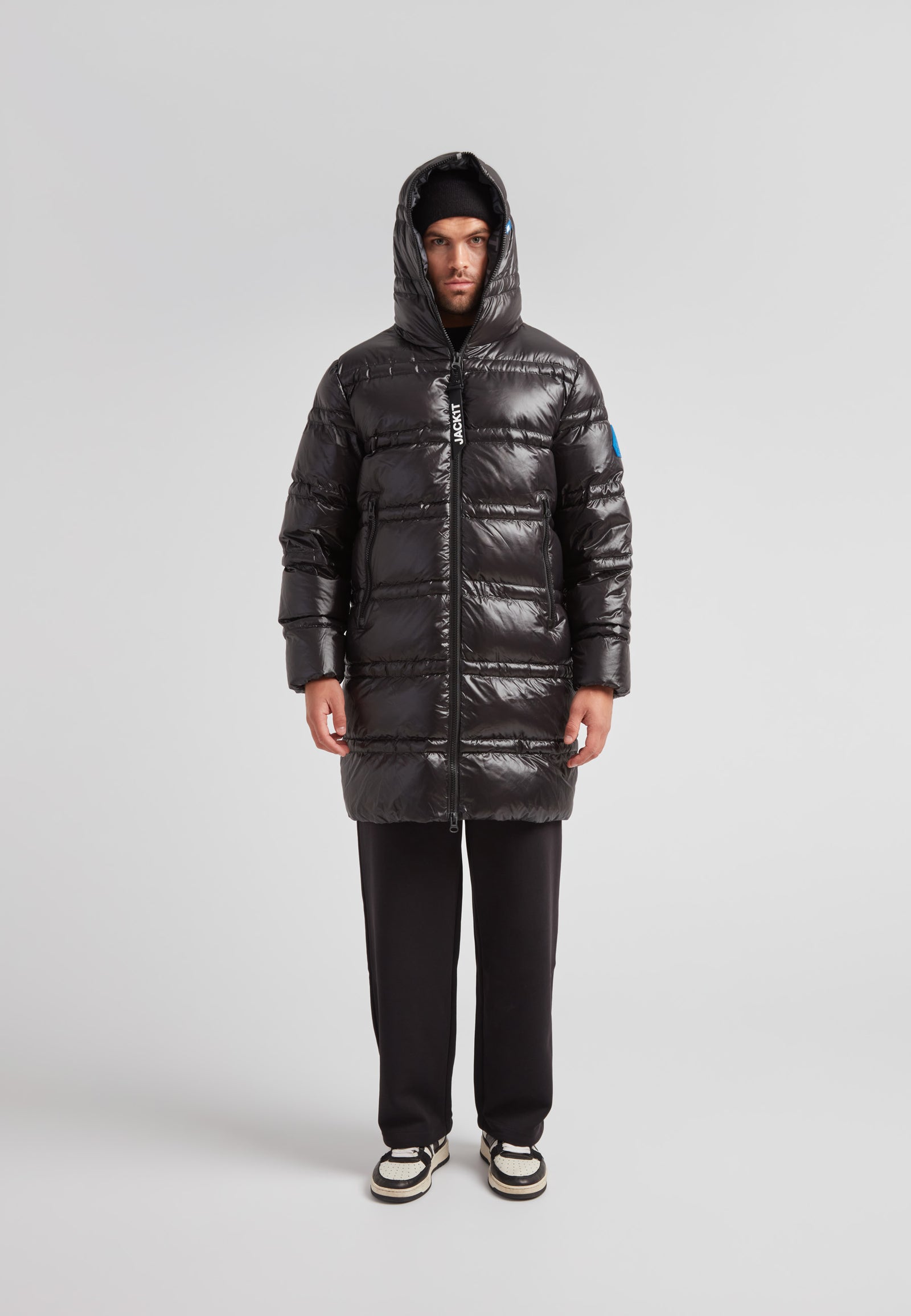 R4D Tramline Puffer Coat Lux Black worn by a model, showcasing its longline design and insulated features.