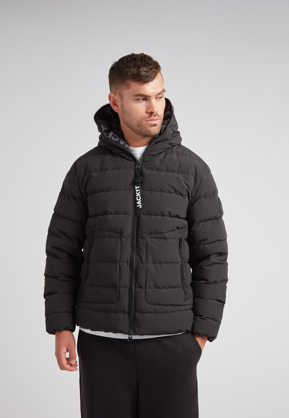 R4D Tramline Puffer Racer Jacket Matt Black worn by a man, showcasing its modern puffer design and adjustable features.