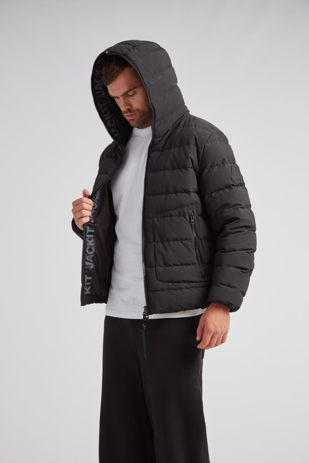 R4D Tramline Puffer Racer Jacket Matt Black on model with hoodie, showcasing technical craftsmanship and modern design.
