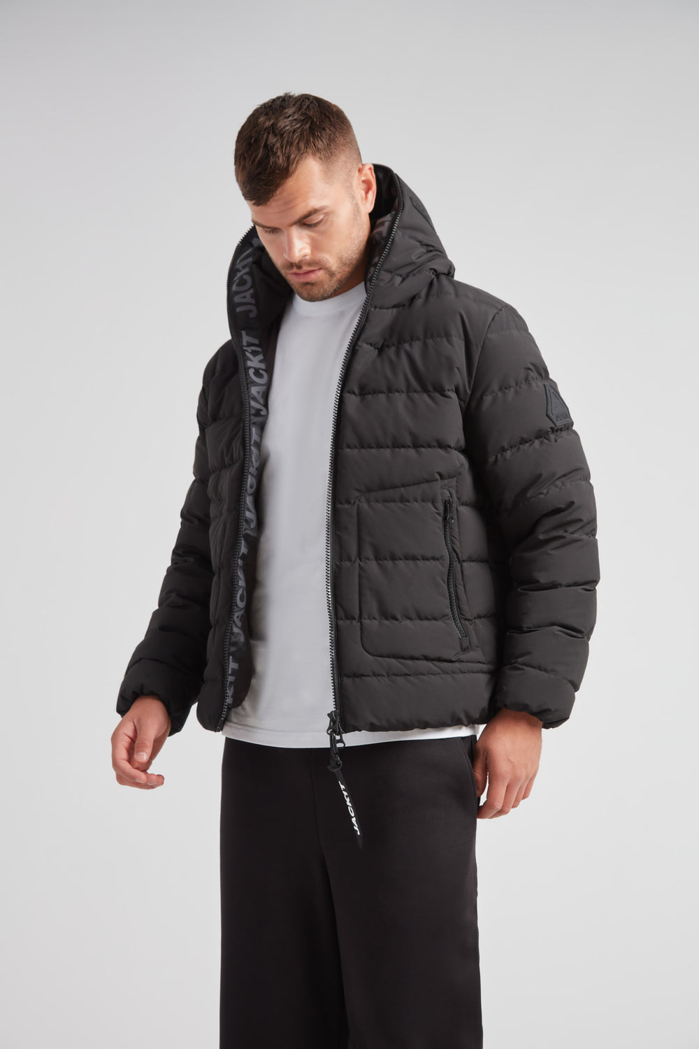 R4D Tramline Puffer Racer Jacket Matt Black worn by a man in a modern, stylish setting.