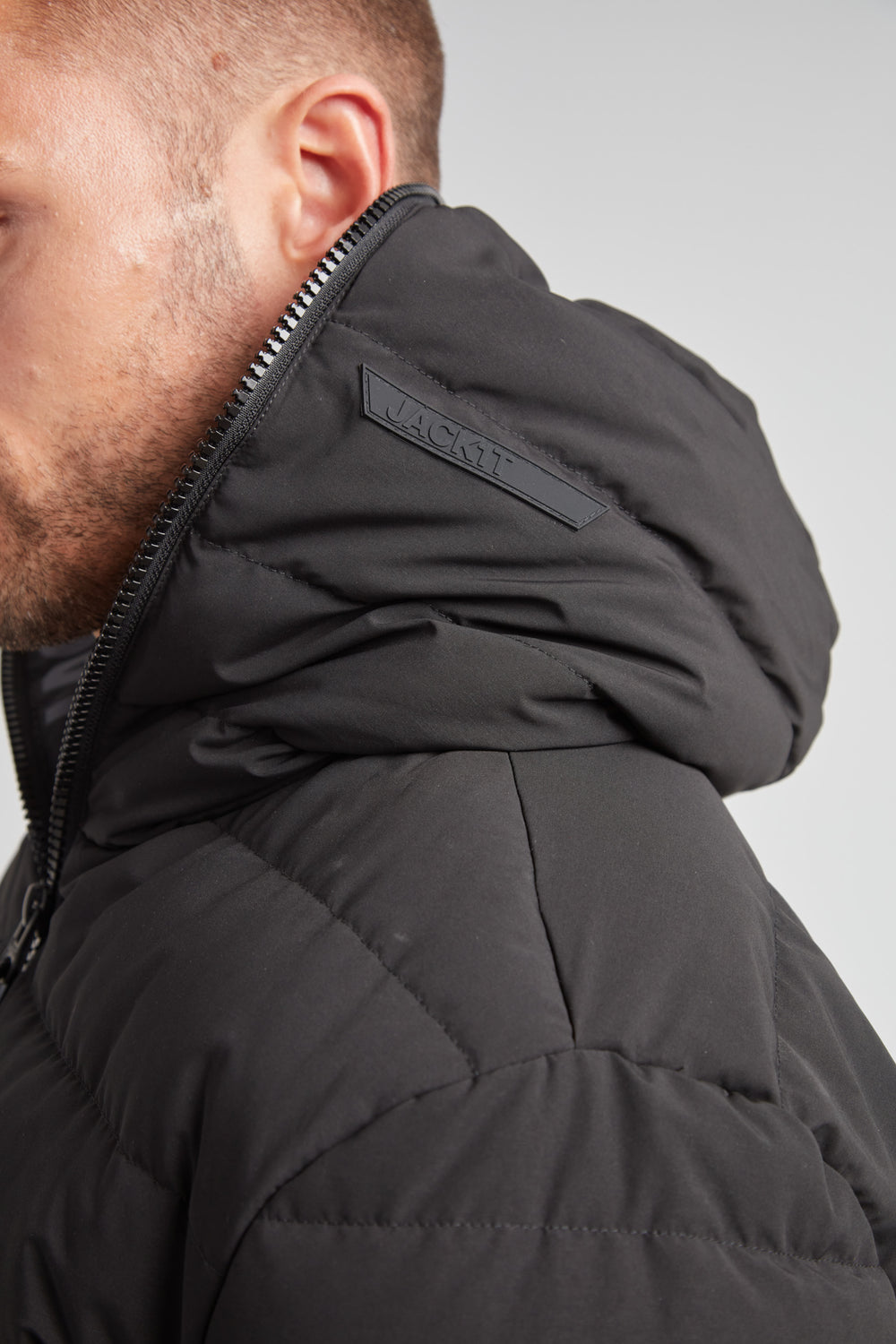 Side view of R4D Tramline Puffer Racer Jacket Matt Black showcasing its stylish hood and sleek design.