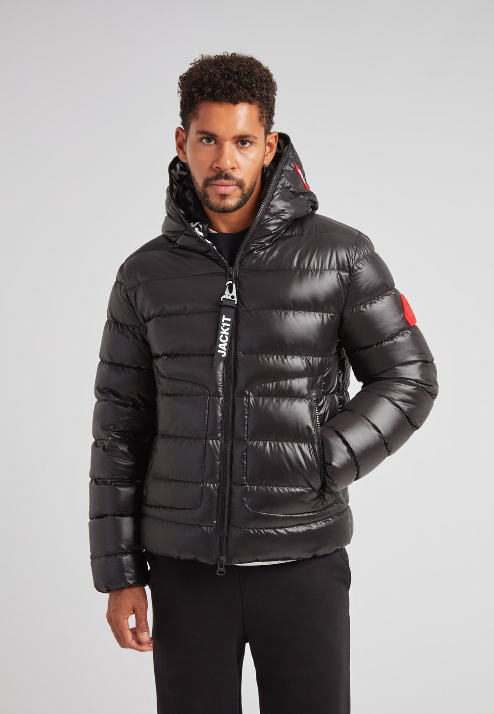 R4D Tramline Puffer Racer Jacket Lux Black on model in sleek black with hood, showcasing modern technical outerwear design.