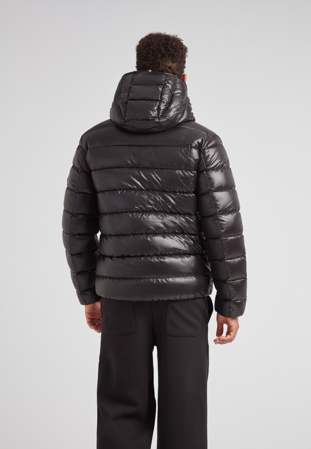 R4D Tramline Puffer Racer Jacket Lux Black seen from the back, showcasing its sleek design and hood.
