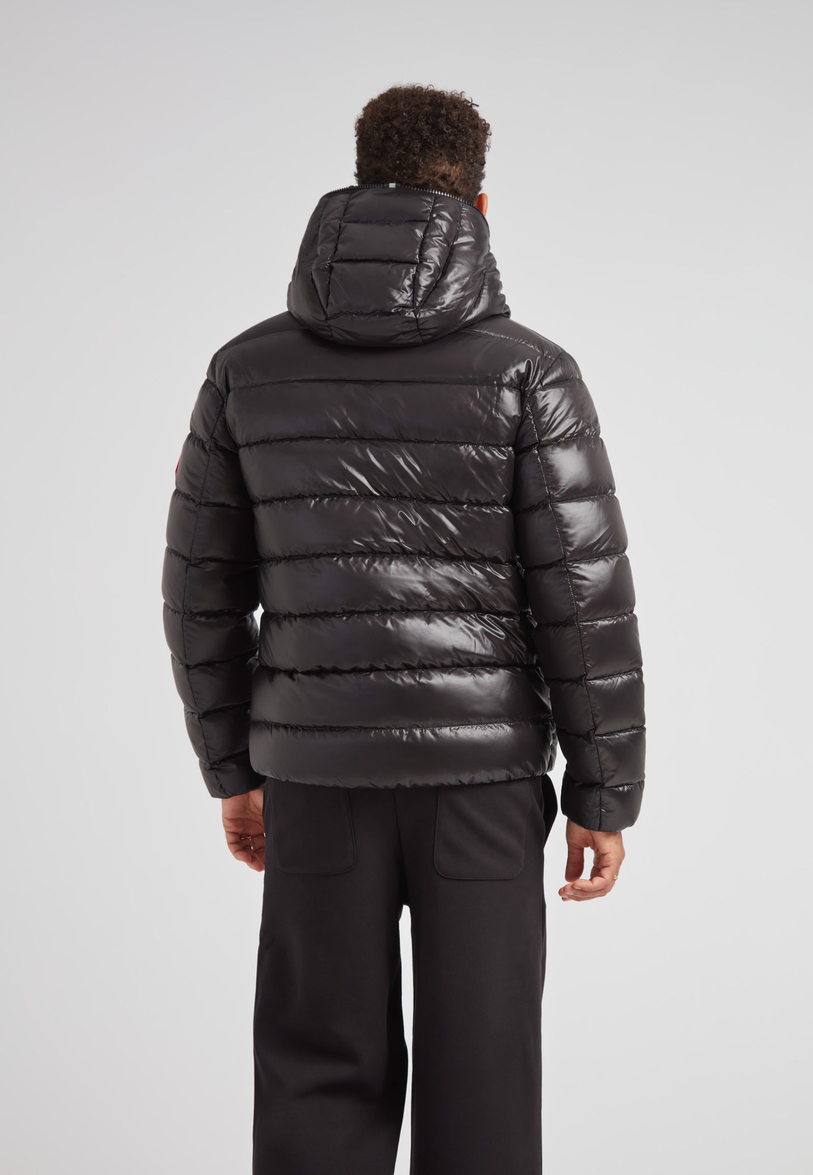 R4D Tramline Puffer Racer Jacket Lux Black seen from the back, showcasing its sleek design and hood.