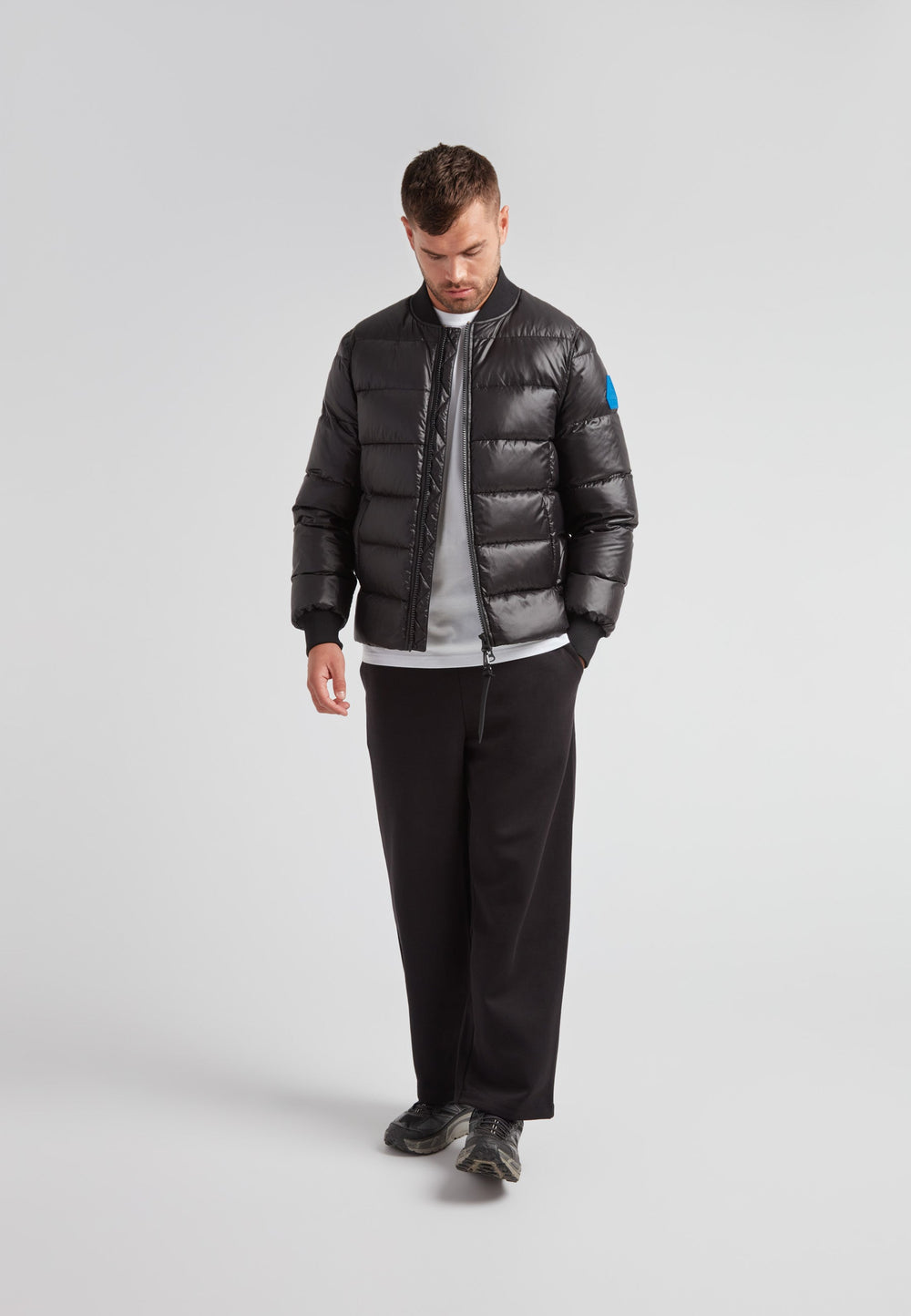 Vortex Black Bomber Jacket worn by a man, showcasing its sleek design and comfortable fit.