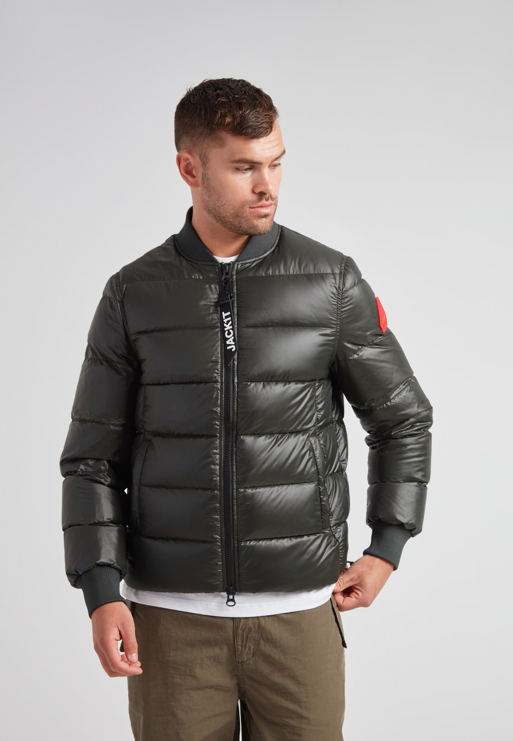 Vortex olive bomber jacket worn by a man, showcasing its modern design and durable nylon material.