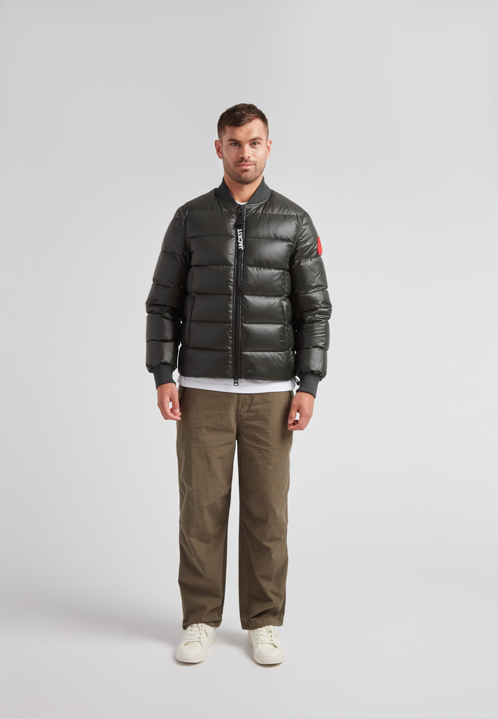 Man wearing a Vortex olive bomber jacket with a stylish design and durable material.