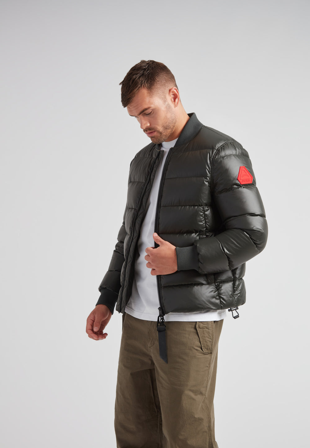 Man wearing Vortex olive bomber jacket, showcasing its sleek design and comfort.