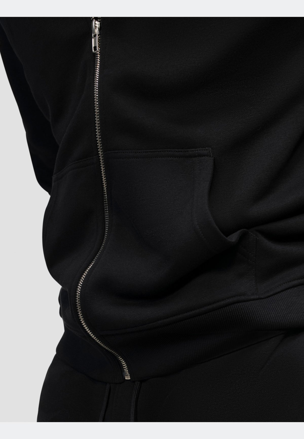 Close-up of a black hoodie with zip and pocket detail for casual, stylish wear.