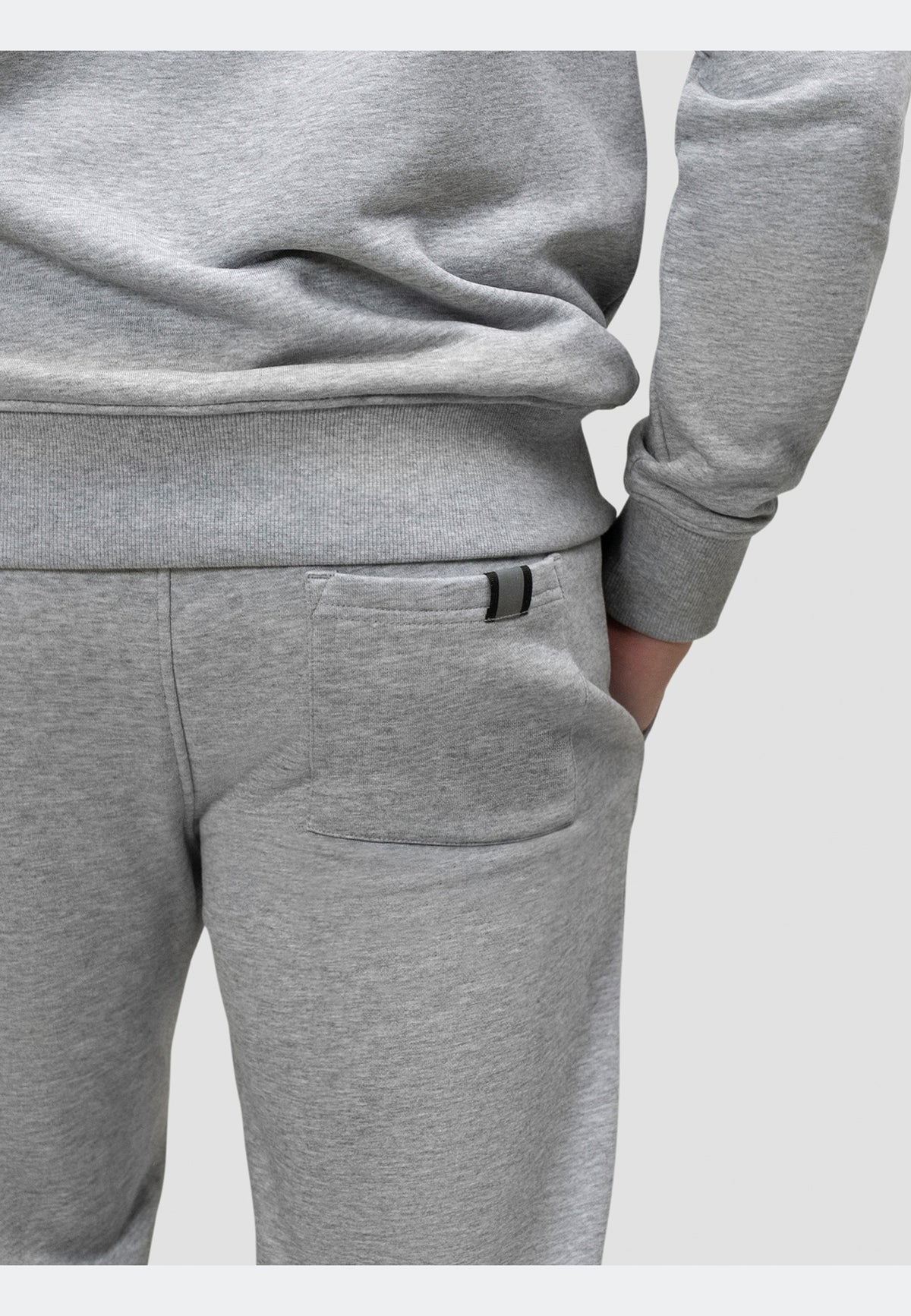 Close-up of grey joggers with pockets and elasticated waistband for a relaxed look.