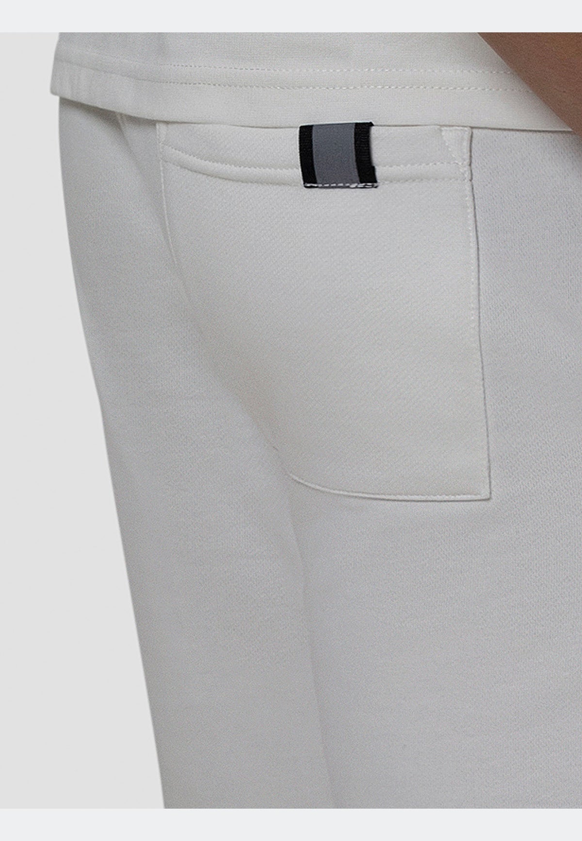 Close-up of the back pocket detail on off white joggers, showcasing refined stitching and structured design.