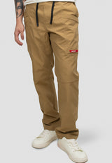 Model wearing men's sand cargo trousers with elastic waist and relaxed fit, ideal for everyday wear and travel.
