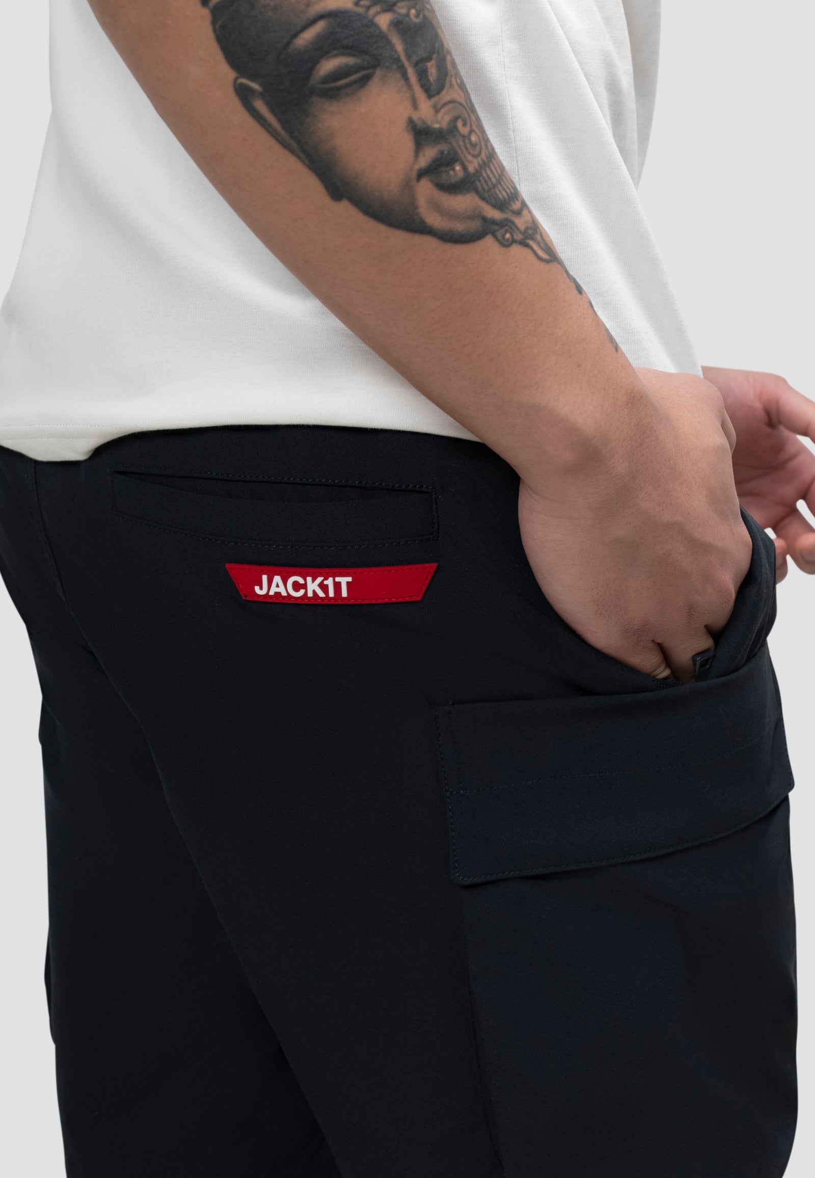 Model wearing men's navy cargo shorts with elastic waist and JACKIT branding pocket.