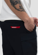 Model wearing men's navy cargo shorts with elastic waist and JACKIT branding pocket.