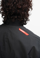 Mens black bomber jacket from Oberon Tech featuring a distinctive logo on the back, showcasing stylish design.