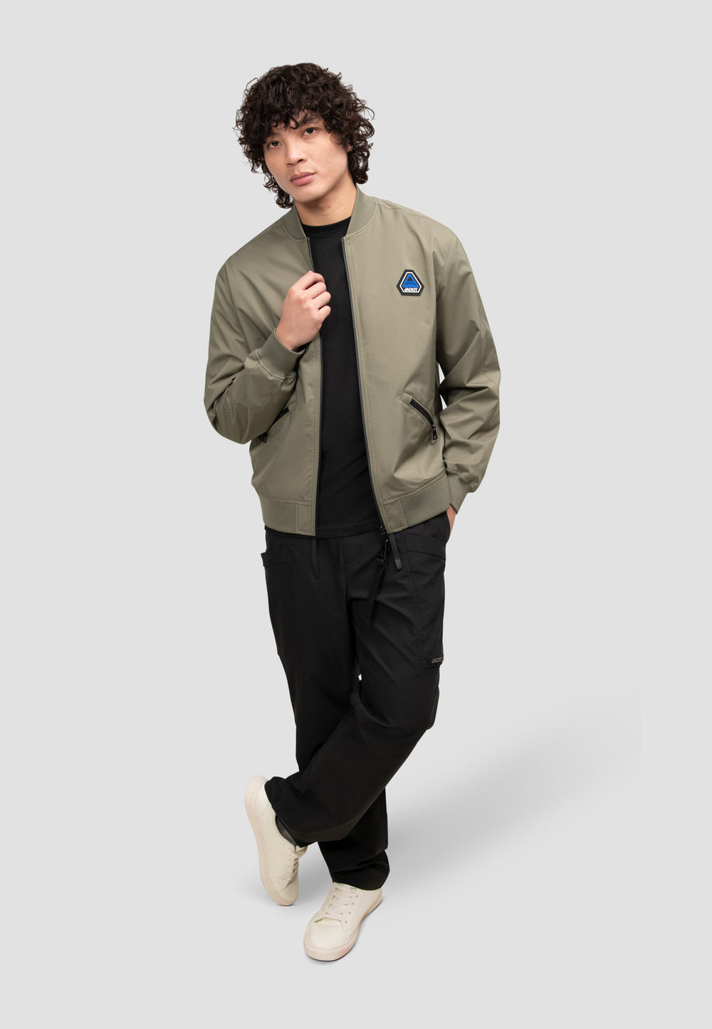 Model wearing a mens olive bomber jacket, showcasing a lightweight design and modern fit in Dusty Olive color.