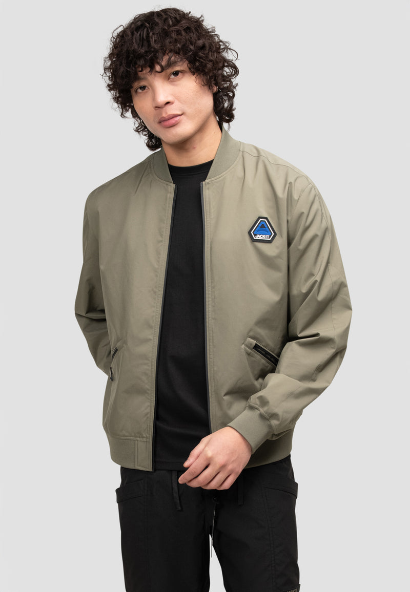 Model wearing mens olive technical bomber jacket, showcasing its stylish design and lightweight fabric.