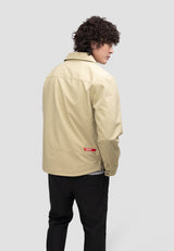 Model wearing a Mens Sand Shirt Jacket, showcasing the back view of the lightweight, water-resistant fabric.